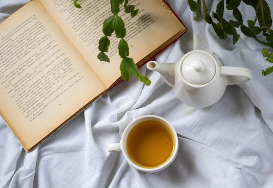 un-livre-ouvert-et-une-tasse-de-the-sur-un-lit-0B4j8CTnuA8