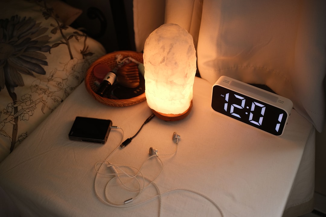 table-de-chevet-avec-une-lampe-une-horloge-et-des-chargeurs-2kKThodpTvw