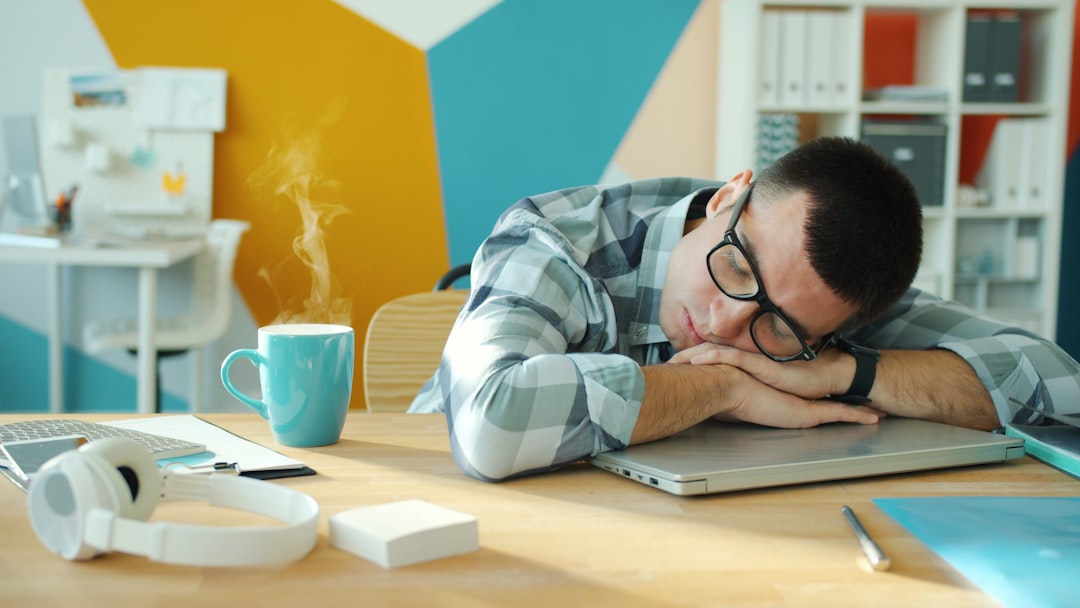 homme-dormant-a-un-bureau-avec-du-cafe-et-un-ordinateur-portable-xolfPucwlPA